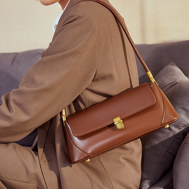 Sac baguette marron porté à l’épaule, en simili cuir avec bandoulière