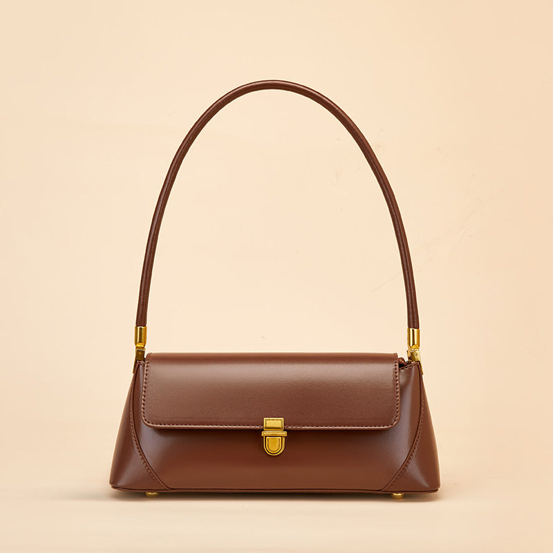 Sac baguette marron porté à l’épaule, en simili cuir avec bandoulière