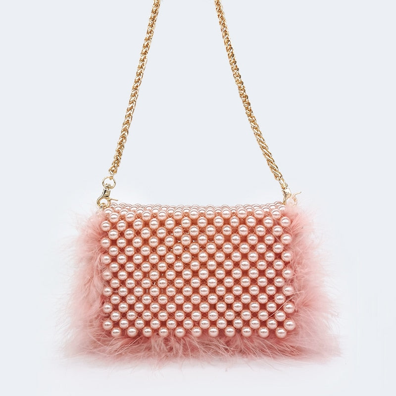 Sac pochette perle et fausse fourrure rose avec chaîne dorée, perles nacrées et finitions élégantes