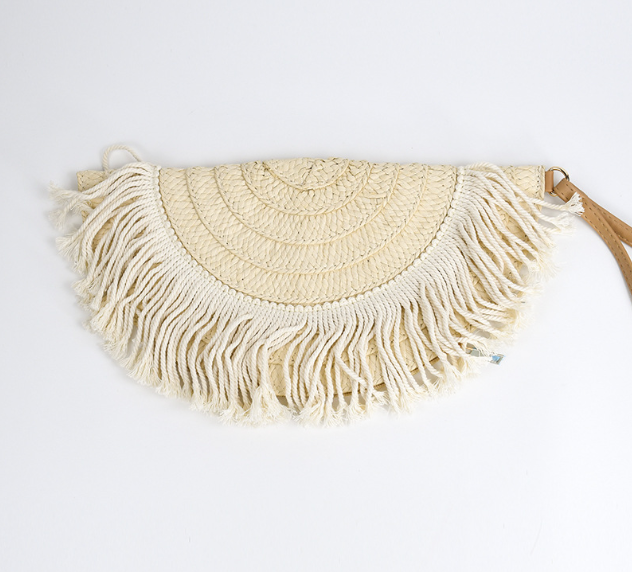 Pochette d’été rétro en paille naturelle, forme demi-lune, avec détails colorés corail et turquoise, format 33x16,5 cm, portée à la main